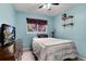 Cozy bedroom features blue walls, a ceiling fan, and a bright window at 12104 Ivanhoe Ct, Brighton, CO 80602
