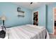 Bedroom features a ceiling fan, light blue walls, and shelves for storage at 12104 Ivanhoe Ct, Brighton, CO 80602
