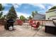 Enjoy the outdoors on this wooden deck with comfortable red seating and a grill for summer barbecues at 12104 Ivanhoe Ct, Brighton, CO 80602