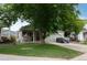 Charming single-story home featuring a well-maintained lawn, mature tree, and covered front porch with swing at 12104 Ivanhoe Ct, Brighton, CO 80602