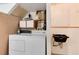 Functional laundry room featuring white washer and dryer with storage cabinets at 12104 Ivanhoe Ct, Brighton, CO 80602