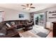 Relax in the spacious living room featuring a ceiling fan, plush seating, and outdoor access at 12104 Ivanhoe Ct, Brighton, CO 80602