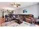 The living room features a plush sectional sofa, ceiling fan, and open access to the kitchen and dining area at 12104 Ivanhoe Ct, Brighton, CO 80602