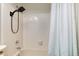 Shower features black shower head, white tiled walls and bathtub, and light curtain at 12104 Ivanhoe Ct, Brighton, CO 80602