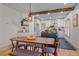 Open-concept dining area features a wooden table, beam accents, and modern lighting fixtures overlooking the kitchen at 5614 Yarrow St, Arvada, CO 80002