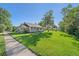 Charming home featuring a lush green lawn with shade trees and a welcoming covered front porch at 5614 Yarrow St, Arvada, CO 80002