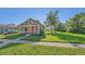 Cozy home featuring a covered porch, lush lawn with shade tree, and a welcoming red front door at 5614 Yarrow St, Arvada, CO 80002
