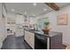 Modern kitchen featuring a center island, white cabinetry, and stainless steel appliances for culinary enthusiasts at 5614 Yarrow St, Arvada, CO 80002
