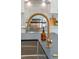 Close up on a gold kitchen faucet over a stone countertop with stainless steel appliances in the background at 5614 Yarrow St, Arvada, CO 80002