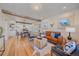 Inviting living room with exposed beams, leather sofa, and hardwood floors, perfect for relaxing and entertaining at 5614 Yarrow St, Arvada, CO 80002