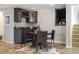 Basement wet bar with dark cabinetry, wine storage, and small table at 16587 W 53Rd Way, Golden, CO 80403