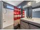 Bright bathroom features a shower-tub combo, and a wood vanity with a modern faucet at 2404 S Genoa Way, Aurora, CO 80013
