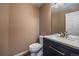 Half bathroom features modern fixtures, including dark cabinetry and attractive countertop with a white vessel sink at 2404 S Genoa Way, Aurora, CO 80013
