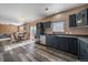 Modern kitchen features stainless steel appliances, dark cabinetry, stone counters and stylish wood flooring at 2404 S Genoa Way, Aurora, CO 80013