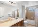 Bright bathroom featuring a vanity with a large mirror and a shower over tub at 17378 W 78Th Dr, Arvada, CO 80007