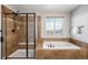 Bathroom showcasing a glass enclosed shower and an adjacent soaking tub with tile surround at 17378 W 78Th Dr, Arvada, CO 80007