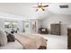 Bright bedroom featuring a ceiling fan, balcony access, and a comfortable seating area at 17378 W 78Th Dr, Arvada, CO 80007