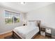 Cozy bedroom features a comfortable bed, natural light, and hardwood floors at 17378 W 78Th Dr, Arvada, CO 80007