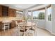 Sunlit breakfast nook featuring a round table, large windows, and built-in cabinetry with ample storage at 17378 W 78Th Dr, Arvada, CO 80007