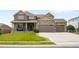 Beautiful two-story house with stone accents, a well-manicured lawn, and an attached three-car garage at 17378 W 78Th Dr, Arvada, CO 80007