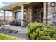 Welcoming front porch with stone accents, a seating area, and landscaping that enhances the home's curb appeal at 17378 W 78Th Dr, Arvada, CO 80007