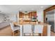 Gourmet kitchen featuring a large island with seating, stainless steel appliances, and rich wood cabinetry at 17378 W 78Th Dr, Arvada, CO 80007