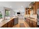Open-concept kitchen showcasing an island with bar seating, stainless steel appliances, and seamless flow to living area at 17378 W 78Th Dr, Arvada, CO 80007