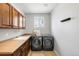 Well-equipped laundry room with sleek appliances, cabinets, and countertop space at 17378 W 78Th Dr, Arvada, CO 80007