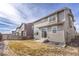 A fenced backyard features a partially-dry lawn and sliding glass door entry at 10962 Vaughn St, Commerce City, CO 80022