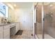 Bright bathroom featuring double vanity, granite counters, and tiled shower at 10962 Vaughn St, Commerce City, CO 80022