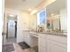 Bright bathroom with double vanity, granite countertops, and walk-in closet at 10962 Vaughn St, Commerce City, CO 80022