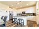 Bright, modern kitchen with white cabinets, stainless steel appliances, island with barstools, and pendant lighting at 10962 Vaughn St, Commerce City, CO 80022