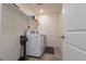 Modern laundry room with washer, dryer, floating shelf, and neutral-toned tiled floor at 10962 Vaughn St, Commerce City, CO 80022