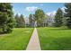 Well-manicured lawns lead to inviting residential buildings nestled among mature trees at 7434 Singing Hills Ct, Boulder, CO 80301