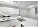 Kitchenette area featuring white cabinets, electric stove, a microwave and a sink at 7434 Singing Hills Ct, Boulder, CO 80301