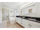 This bathroom includes double sinks, black countertop and tile flooring at 10166 Grove Loop # D, Westminster, CO 80031