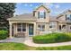 Charming home featuring a covered front porch, green door, and well-manicured landscaping at 10166 Grove Loop # D, Westminster, CO 80031