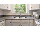 Bright kitchen sink features granite countertops, white cabinetry, and natural light at 10166 Grove Loop # D, Westminster, CO 80031