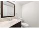 Clean bathroom with dark vanity, toilet and a framed mirror at 2768 S Lansing Way, Aurora, CO 80014