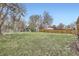 Large grassy backyard with a wooden fence, playset, and storage shed at 11864 E Idaho Dr, Aurora, CO 80012