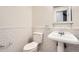 Bathroom features a toilet, pedestal sink, tiled walls, and a mirror at 11864 E Idaho Dr, Aurora, CO 80012