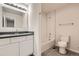Modern bathroom with a subway-tiled shower, gray vanity, and sleek fixtures at 11864 E Idaho Dr, Aurora, CO 80012