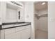 Bathroom vanity featuring white cabinetry, dark countertop, and a walk-in closet at 11864 E Idaho Dr, Aurora, CO 80012