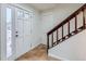 Inviting entryway featuring tiled floors, a wooden staircase, and a bright white front door at 11864 E Idaho Dr, Aurora, CO 80012