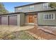 Two-story home featuring an attached three-car garage, brick accents, and a well-maintained front yard at 11864 E Idaho Dr, Aurora, CO 80012