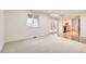 Living room featuring neutral carpet and access to the back patio and kitchen at 11864 E Idaho Dr, Aurora, CO 80012