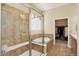Bathroom featuring a glass-enclosed shower and soaking tub with tile surround and a walk-in closet in view at 8582 E 148Th Ln, Thornton, CO 80602