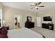 A bedroom featuring a ceiling fan, TV, and ensuite bathroom partially visible through an open door at 8582 E 148Th Ln, Thornton, CO 80602
