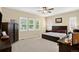 Spacious bedroom featuring a ceiling fan, plush carpet, and shuttered windows offering plenty of natural light at 8582 E 148Th Ln, Thornton, CO 80602