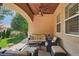 Comfortable covered outdoor patio area with comfortable seating and mature trees at 8582 E 148Th Ln, Thornton, CO 80602